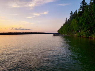 Sunset and tree-lined shoreline on Child's Lake in Duck Mountain Provincial Park, Manitoba, Canada