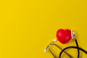 Top view world heart day stethoscope with red heart on yellow background.Free copy space