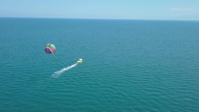 Parasailing - People On Parachute Enjoying The Beautiful Scenery On Summer Towed Behind The Motorboat In Greece. - aerial