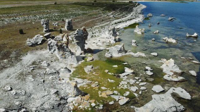Aerial view of huge rocks on coast and in water, zooming shot