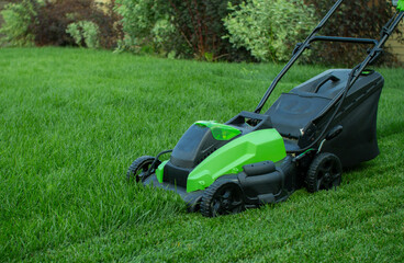 Fototapeta na wymiar Lawn mower on a green lawn.