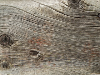 Natural old weathered wood texture boards cracks lines curves knots close-up.