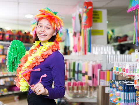 Cheerful young female having fun in festival outfits store while preparing for party