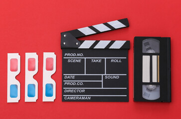 Fototapeta na wymiar Film clapper board, 3d glasses, video cassette on red background. Top view