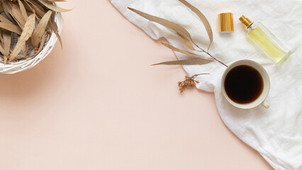 Eucalyptus leaves and a cup of black coffee with a bottle of essence on a light background with empty space.