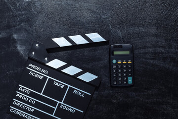 Movie clapper board and calculator on chalk blackboard. Cinema industry, entertainment