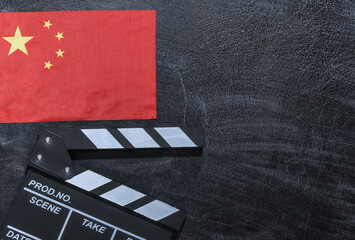 Movie clapper board and China flag on chalk blackboard. Cinema industry, entertainment