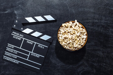 Movie clapper board, popcorn bowl on chalk blackboard. Cinema industry, entertainment