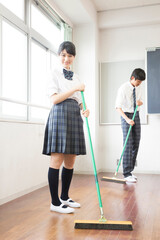 教室の掃除をする高校生男女