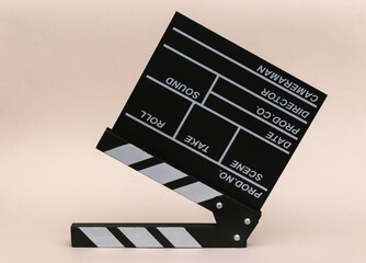 Fototapeta na wymiar Movie clapper board on beige background. Cinema industry, entertainment