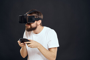 man wearing virtual reality glasses with gamepad in hand technology games leisure dark background