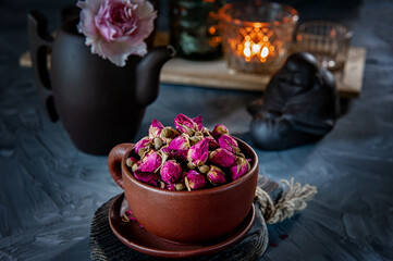 brown ceramic Cup of rosebud tea sits on a wooden table. Tea time, cozy atmosphere. Kitchen still...
