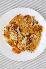 Homemade Fried Hashbrowns on a white plate, overhead view. Flat lay, top view, from above.