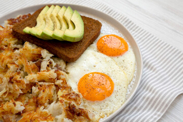 Tasty Homemade Fried Hashbrowns and Eggs on a plate, low angle view. Copy space.