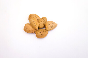 Inshell almonds on a white background. Almonds are arranged in a pile.