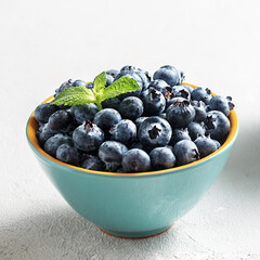 Fresh blueberries in a bowl on a concrete surface.