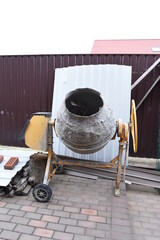 Concrete mixer on backyard landscape or building site private territory. Local construction business