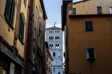 Fototapeta na wymiar View of San Michele in Foro Church Tower between Buildings, Lucca, Italy