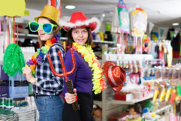 Nice girl having fun in festival outfits store while preparing for party with her friend
