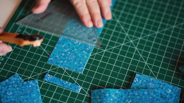 Grandma cuts fabrics for patchwork on a special green rug