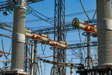 Power generating plant. Transformer substation on blue factory building and sky background. Orange...