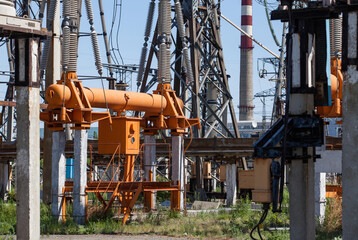 Transformer substation on blue sky background. Orange high-voltage switcher, insulators and...