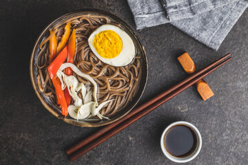 Asian noodle soup with soba noodles, vegetable and egg in bowl.