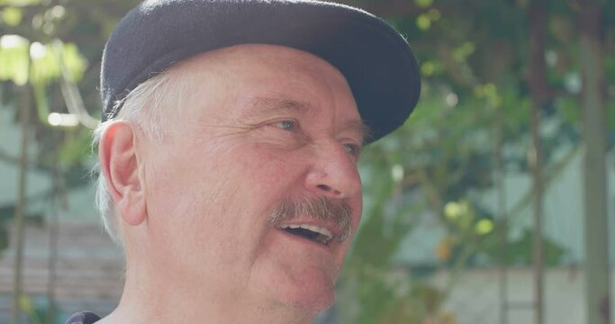 Portrait of a senior with blonde gray moustache is talking.