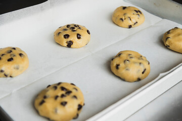 raw chocolate chip cookie dough on a baking sheet ready to bake