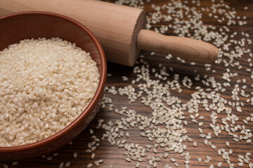 organic rice in clay bowl and rolling pin