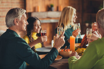Photo of full family thanks giving gathering sit table turkey served dinner drink sparkling wine say toast living room indoors