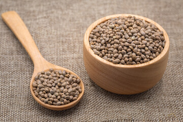 Hemp seeds in wooden spoon. Copy space. CBD hemp oil.