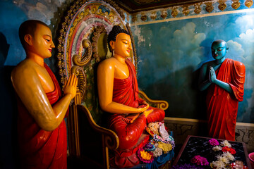 Ancient colorful statue of Buddha and monks in Ella Temple in Ella town on the island of Sri Lanka