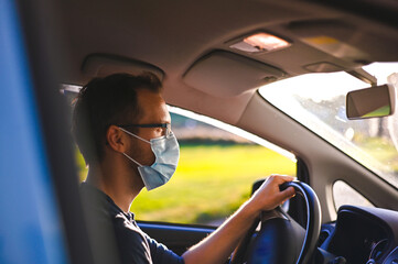 Naklejka premium portrait of attractive nerd in long sleeve glasses and protective face mask in electric car at sunset