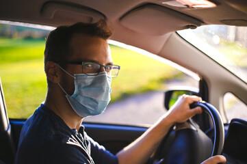 portrait of attractive nerd in long sleeve glasses and protective face mask in electric car at...