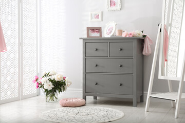 Grey chest of drawers in stylish room interior