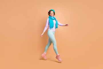 Fototapeta na wymiar Full length body size view of her she nice attractive lovely pretty charming cheerful cheery girl jumping walking wearing modern mint lavender garment isolated over beige pastel color background