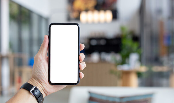 cell phone mockup blank white screen.man hand holding texting using mobile on desk at coffee shop.background empty space for advertise.work people contact marketing business,technology