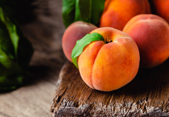 Peach fruit with leaf. Ripe juicy orange peach fruit of peach tree on wooden cutting rustic board....