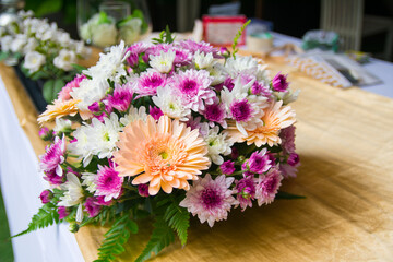 Wedding bouquet of purple and white flowers lying on wooden floor