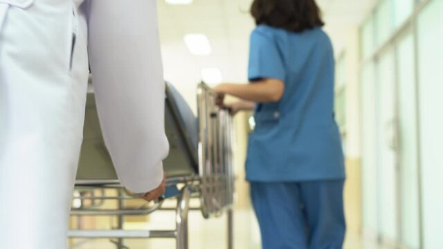  Nurse is wheeling an emergency patient bed in a hospital.