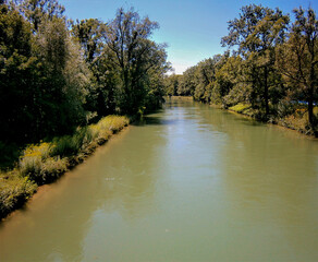 A waterway with the name Isarwerk Canal. It is lined with dense tree growth.