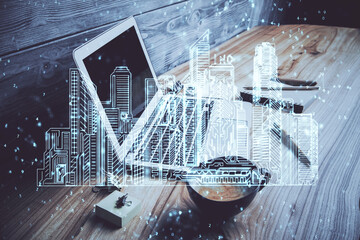Desktop computer background in office and big town buildings hologram drawing. Double exposure. Smart city concept.