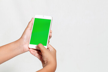 Woman hand holding the white smartphone with green blank screen isolated on white background