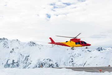 Mountain ski life rescue medic helicopter taking-off from station helipad to search injured skiers and help at accident. Emergency chopper at austrian alpine skiing resort. Alps landsape © Kyryl Gorlov