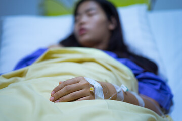 Woman patients lying on bed in hospital. Hands with saline solution.