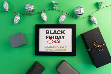 Fototapeta na wymiar Black Friday Sale concept, gift box with photo frame on green background