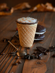 A warm autumn coffee in a waffle cup with tasty cookies