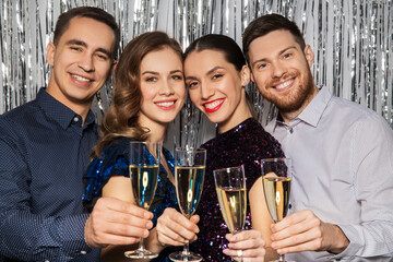 celebration and holidays concept - happy friends toasting champagne glasses at party