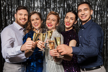 celebration and holidays concept - happy friends clinking champagne glasses at party